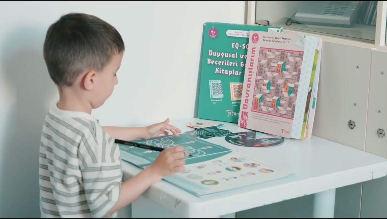 Okuma yazmaya hazırlık kitabıyla çalışan çocuk