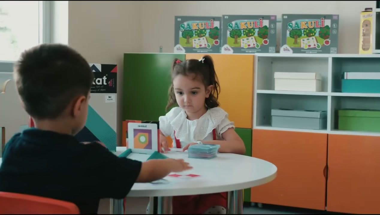 Renkli dolaplı sınıfta yuvarlak masada etkinlik yapan çocuklar